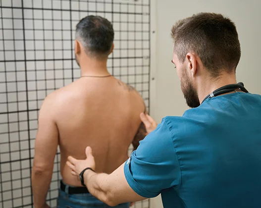 Physiotherapist conducting a posture analysis on a male patient